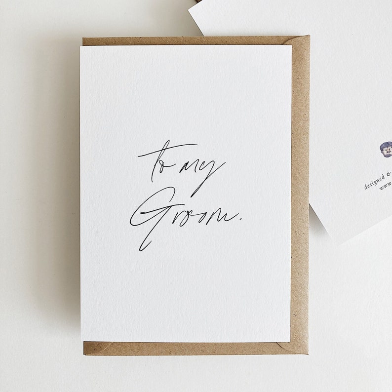 May include: A white card with black calligraphy that reads "to my groom."