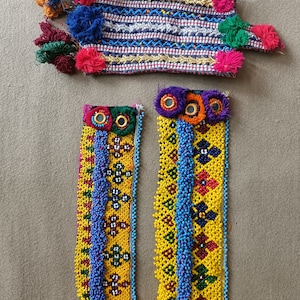 Puede incluir: Tres pulseras de cuentas coloridas con intrincados patrones y borlas. Las pulseras están hechas con cuentas amarillas, azules, rojas, verdes y naranjas.