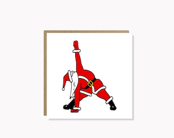 May include: A red and white Santa Claus figure is doing a yoga pose. He is wearing a red suit with a white trim and a black belt. He has a white beard and a red hat.