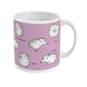 May include: White ceramic mug with a light purple background featuring cartoon hedgehogs in yoga poses. Poses include Sun Salutation, Tree, Bow, Boat, and Cobra. The mug has a white handle and a white interior.