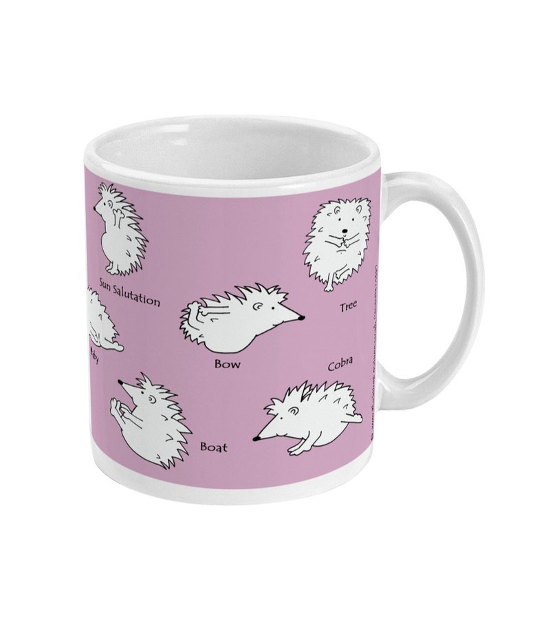 May include: White ceramic mug with a light purple background featuring cartoon hedgehogs in yoga poses. Poses include Sun Salutation, Tree, Bow, Boat, and Cobra. The mug has a white handle and a white interior.