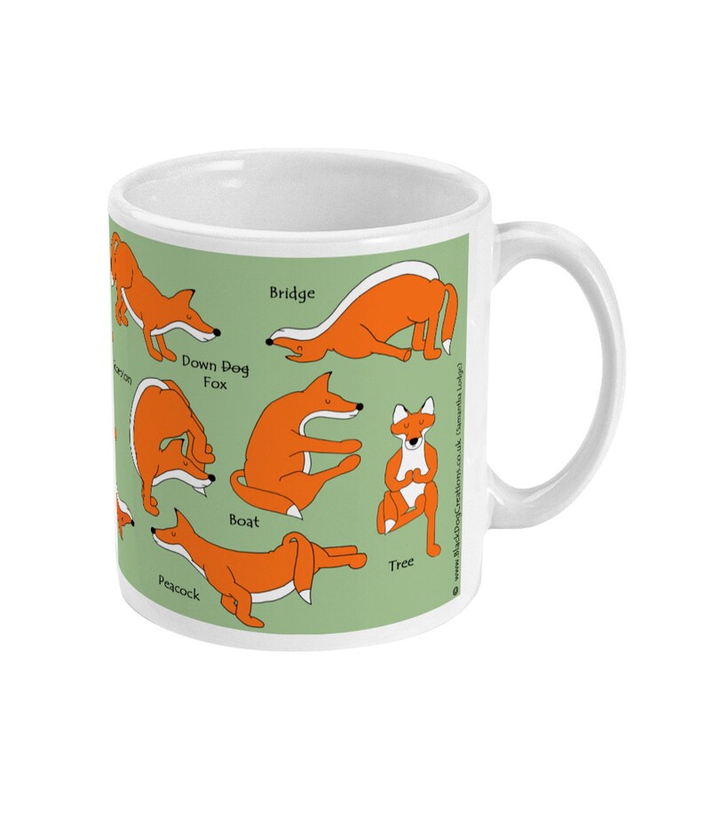May include: White ceramic mug with a green background featuring illustrations of foxes in various yoga poses. The poses are labeled with the names: Down Dog Fox, Bridge, Boat, Tree, and Peacock. The text "www.BlackDogCreations.co.uk Samantha Lady"
