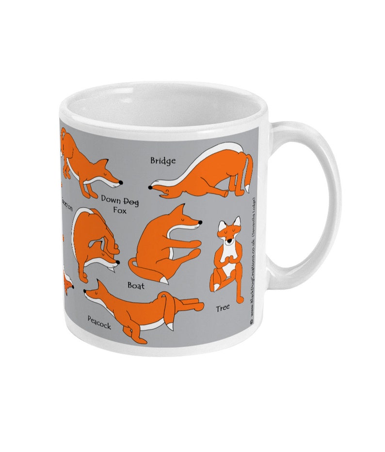 May include: White ceramic mug with a gray background and orange fox illustrations depicting different yoga poses. The poses are labeled with the names: Peacock, Boat, Tree, Bridge, Down Dog Fox.