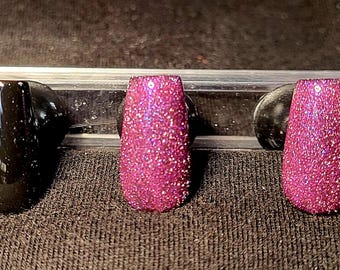 Glitterroze cateye en zwarte, handgeschilderde persnagels