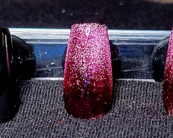 Glitterroze cateye en zwarte, handgeschilderde persnagels