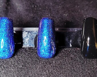 Glitterblauwe kameleon en zwarte, handgeschilderde persnagels
