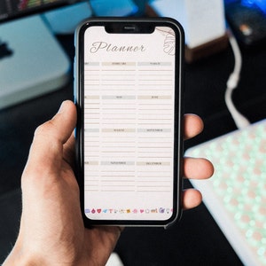 May include: A white and gray digital planner app on a smartphone screen. The app has a simple design with a calendar layout for each month of the year. The app is titled "Planner".