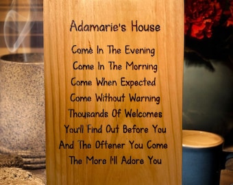 May include: A wooden sign with the text "Adamarie's House" and a poem about welcoming guests. The poem reads: "Come in the evening, come in the morning, come when expected, come without warning, thousands of welcomes, you'll find out before you, and the oftener you come, the more I'll adore you."