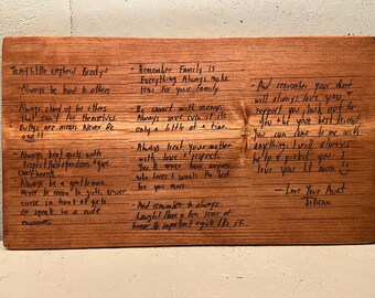 May include: A wooden plaque with handwritten advice for a young person. The text includes phrases like "Always be kind to others", "Always treat your mother with love and respect", and "Love your Aunt Jillena".
