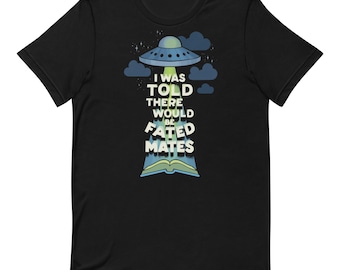 May include: A black short-sleeve t-shirt featuring a graphic of a blue UFO hovering above an open book. The text "I WAS TOLD THERE WOULD BE FATED MATES" is printed in white letters within the light blue beam of light extending from the UFO.