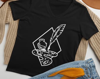 May include: A black V-neck t-shirt featuring a white graphic print of an inkwell, a quill pen, and a swirling cosmic shape containing stars and planets, all framed within a diamond outline. The design is centred on the chest of the shirt.