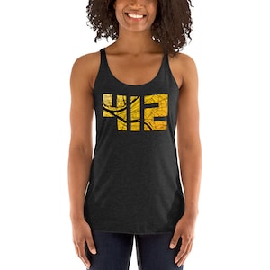 May include: A black tank top with a gold and black graphic of the word "YIE" with a city map design.
