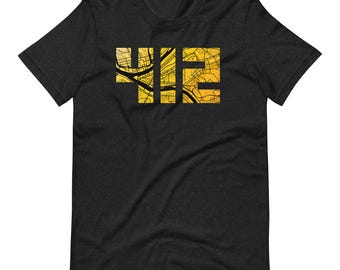 May include: A charcoal grey short-sleeve t-shirt featuring the number 412 printed in a bold, block font. The interior of the numbers is filled with a detailed, golden-yellow street map graphic that shows various roads and city grid lines.