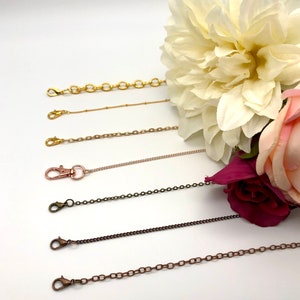 May include: Five different chain styles for jewelry making. The chains are gold, silver, rose gold, bronze, and copper. Each chain has a lobster clasp.