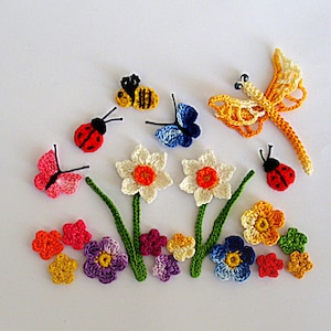 Puede incluir: Decoraciones de flores e insectos de ganchillo en una variedad de colores, incluyendo rojo, amarillo, naranja, rosa, azul y verde. Las decoraciones incluyen una libélula, mariposas, mariquitas, abejas y flores.