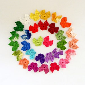 May include: A collection of 20 crocheted flower shapes in a rainbow of colors, arranged in a spiral pattern.
