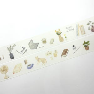 Op de afbeelding: Decoratieve washi tape met aquarel illustraties van alledaagse voorwerpen zoals een laptop, bril, boeken en een kat. De tape bevat de tekst "the joy of being" en "at this moment".