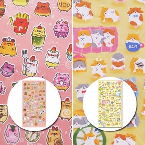 Op de afbeelding: Twee vellen kleurrijke stickers met cartoonberen en hamsters. De stickers bevatten afbeeldingen van voedsel zoals friet, ijs en cupcakes. De hamsterstickers hebben verschillende poses en accessoires.