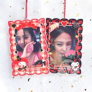 May include: Two clear acrylic photo frames with red and white checkered borders. One features a woman with a pink flower, the other a woman with a rose. Each frame has a cartoon character at the bottom.