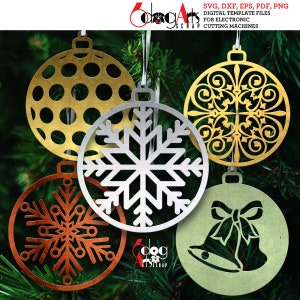 May include: Five decorative Christmas baubles in gold, silver, and copper. Designs include a snowflake, bells, and a patterned circle. The baubles hang against a backdrop of green pine needles. The text "6dog Arts Scrap" is visible.