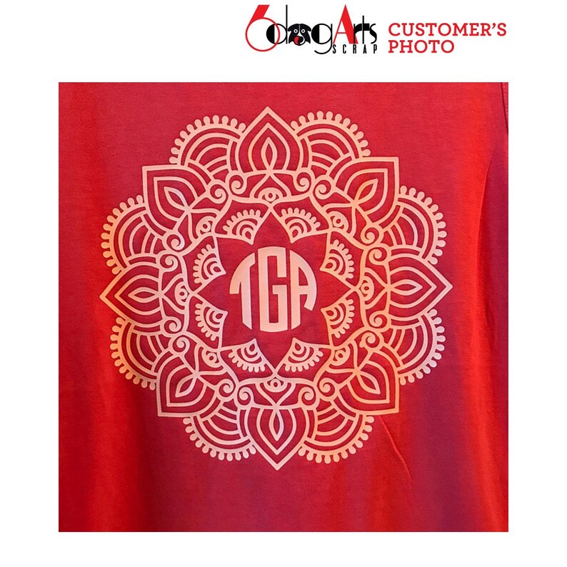 May include: A red t-shirt with a white mandala design featuring a monogram "TGA" in the center.