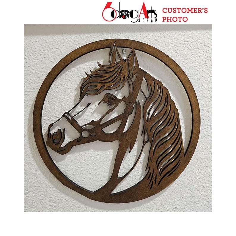 Pode incluir: Silhueta de cabe&ccedil;a de cavalo em madeira dentro de uma moldura circular. O perfil do cavalo &eacute; intrincadamente cortado, mostrando a crina, o olho e a brida. A obra de arte &eacute; de cor castanha quente e est&aacute; montada numa parede branca. O texto "CUSTOMER'S PHOTO" &eacute; vis&iacute;vel.