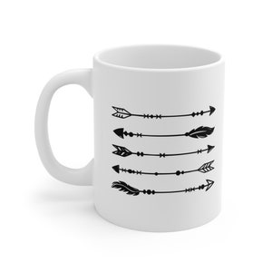 May include: White ceramic mug with a black design of five arrows with different decorative elements, including feathers and dots.