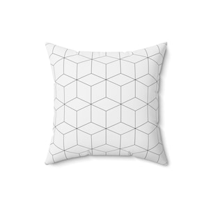 May include: White cushion with a geometric pattern of black lines forming a repeating cube design.