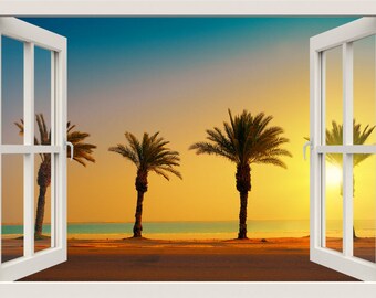 Op de afbeelding: Een uitzicht door een raam op een strandscene met drie palmbomen die zich aftekenen tegen een levendige oranje en gele zonsondergang. De zon gaat onder over de oceaan en werpt een warme gloed op het zand.