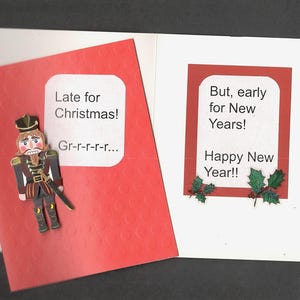 May include: A red Christmas card with a nutcracker figure and the text "Late for Christmas! Gr-r-r-r-r...". Next to it is a white card with a red border and the text "But, early for New Years! Happy New Year!!".