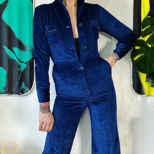 Vintage 1970’s luxe blue velvet corduroy button front jumpsuit with a pop worthy shawl collar and the cutest o-ring zipper chest pockets