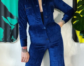 Vintage 1970’s luxe blue velvet corduroy button front jumpsuit with a pop worthy shawl collar and the cutest o-ring zipper chest pockets