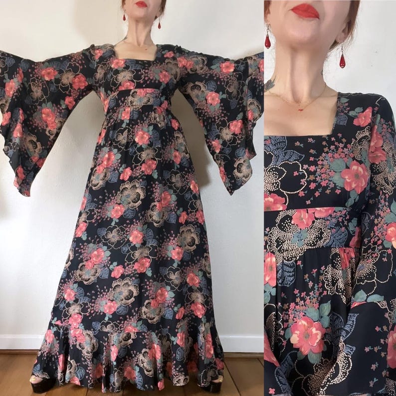 May include: A long black maxi dress with a floral print in shades of pink, green, and blue. The dress has a square neckline, long sleeves, and a flowing skirt.