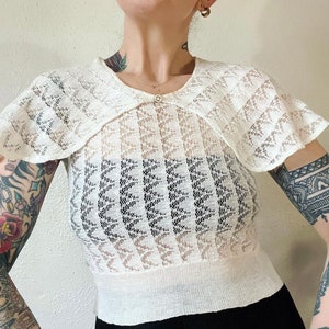 Vintage 1930’s, possibly late 1920’s ivory pointelle knit sweater with caplet neckline & the sweetest mother of pearl pin that adorns the fr