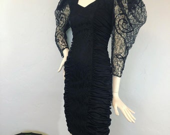 Vintage 1980’s black slinky knit and lace blouson puff sleeve, open back, mini bodycon dress by Mayvens Of California, vintage vampy dress