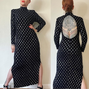 May include: A black maxi dress with a silver glitter pattern and a low back. The dress has long sleeves and a high neckline.