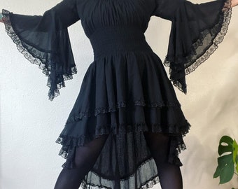 Vintage 1970’s black tissue weight cotton and lace tapered angel sleeve dress with a dramatic hi-lo hem and stunning smocked waistline. Vamp