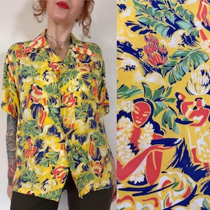 May include: Yellow button-down shirt with a tropical print featuring figures, flowers, and foliage in red, blue, and green. The shirt has short sleeves and a classic collar, perfect for a casual, summery look.