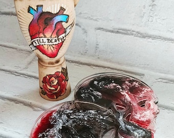 Peut inclure: Deux sous-verres en résine en forme de crâne avec un motif marbré noir et blanc et des accents rouges. Les sous-verres sont sur un fond de brique blanche.
