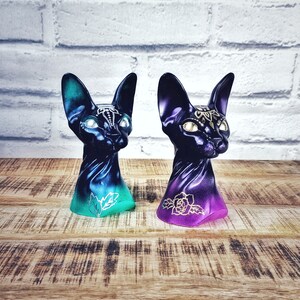Sphynx bust statue ornament with custom tattoo designs. Egyptian feline cat cast sculpture. Dual colour background