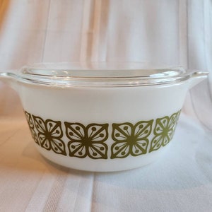 May include: White casserole dish with a green floral pattern. The dish has a glass lid.
