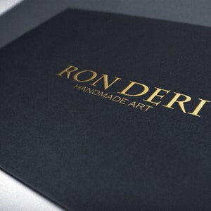 以下が含まれることがあります： 黒いカードに金色の文字で「RONDERI HANDMADE ART」と印刷されています。
