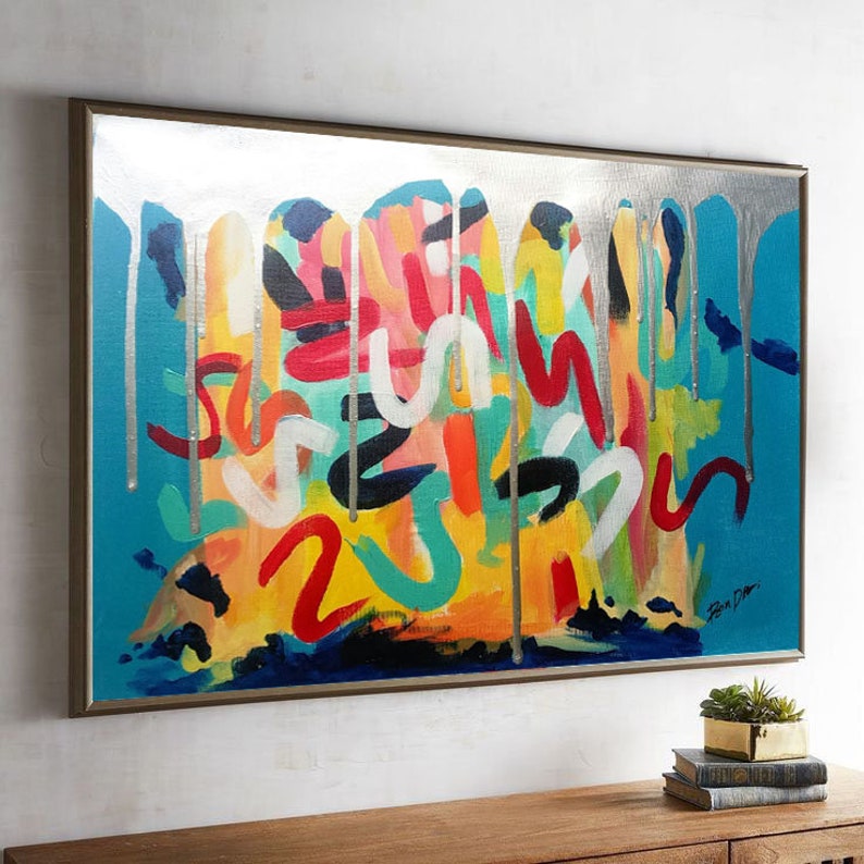 以下が含まれることがあります： 青、黄、赤、オレンジ、緑、白、黒の色合いで、カラフルな絵の具が垂れている抽象画。絵は銀色の額縁に入っています。