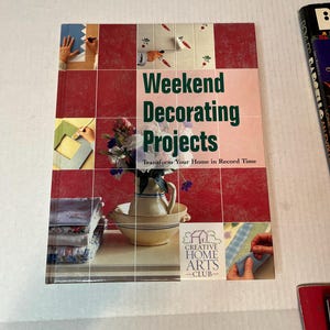May include: Book cover with a red background and the title "Weekend Decorating Projects: Transform Your Home in Record Time". The book is from the Creative Home Arts Club.