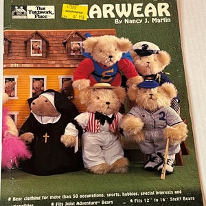 Op de afbeelding: Boekomslag "ARWEAR" van Nancy J. Martin, met teddyberen in verschillende kostuums. De beren zijn verkleed als non, honkballer, matroos en superheld. De omslag vermeldt dat de kleding geschikt is voor 30,5 cm tot 40,6 cm Steiff-beren.