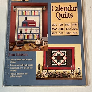 Puede incluir: Un libro titulado "Calendar Quilts" de Joan Hanson. La portada del libro presenta dos diseños de colchas, uno con una escuela y lápices de colores y el otro con una estrella roja y verde. El libro incluye instrucciones para hacer 12 colchas con temas de temporada. Cada colcha mide 91 cm por 122 cm.