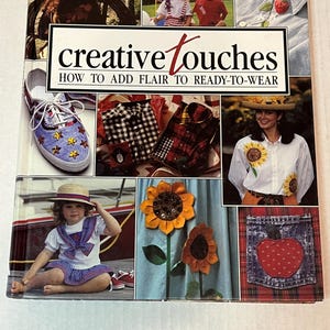 May include: A book cover titled "creative touches" with the subtitle "how to add flair to ready-to-wear." The cover features a collage of images, including decorated clothing, shoes, and children's outfits.