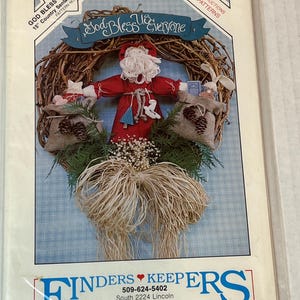 以下が含まれることがあります： 15インチ（約38cm）のカントリーサンタのリースと玩具のクラフトパターン。リースはサンタのフィギュア、松ぼっくり付きのジュートバッグ、そして「God Bless Us Everyone」のテキストが特徴です。パターンには実物大の説明書が含まれています。