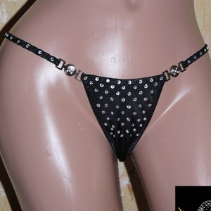 Könnte beinhalten: Schwarze Dessous mit Strassstein-Design und silbernen Beschlägen. Die Dessous befinden sich auf einer Schaufensterpuppe.