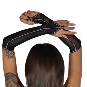 May include: A pair of black mesh fingerless gloves with iridescent rhinestones. The gloves have a cut-out design on the back of the hand.